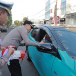 Tebar Semangat Merah Putih Kapolres Jember Turun Jalan Berbagi Bendera dan Cokelat Bagi Pengendara